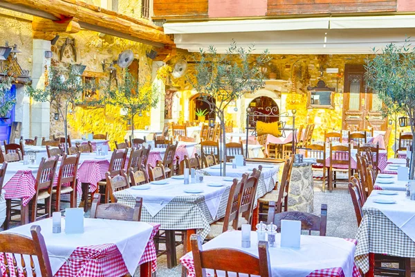 Klasik Cretan açık hava restoranı Chania hizmet tablo ve sanatsal dekore edilmiş duvarlar. Yatay görüntü yönünü