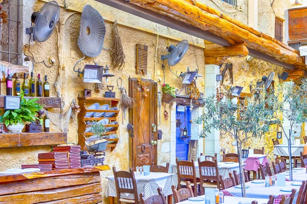 Klasik Cretan açık hava restoranı Chania hizmet tablo ve sanatsal dekore edilmiş duvarlar. Yatay kompozisyon