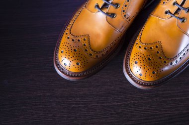 Moda fikirler. Çift erkek ayak parmakları tabaklanmış deri Brogued çizme ahşap arka plan karşı. Görünümünün üzerinde. Yatay resim kompozisyon