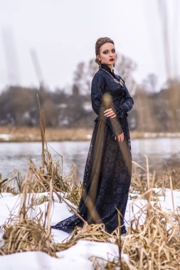 Kolye ve C ile sanat elbiseli genç beyaz esmer kadın