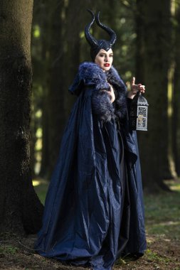 Beyaz kadın Sprin içinde Maleficent giyim ve Horns içinde Poses