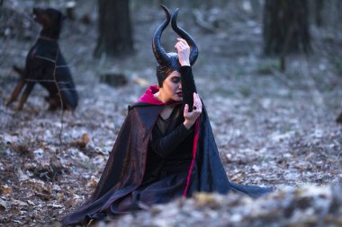 Arka planda yüksek yetiştirilmiş köpek ile gizemli Maleficent kadın. P