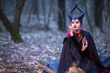 Erken bahar ormanında poz veren gizemli Maleficent kadın.
