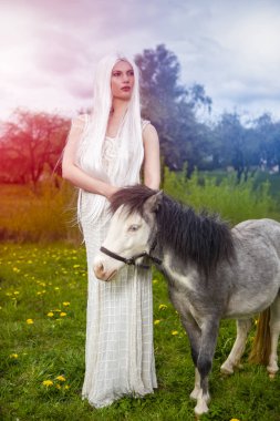 Uzun Beyaz Saçlı Sarışın Kadın Karşı Midilli At ile Poz