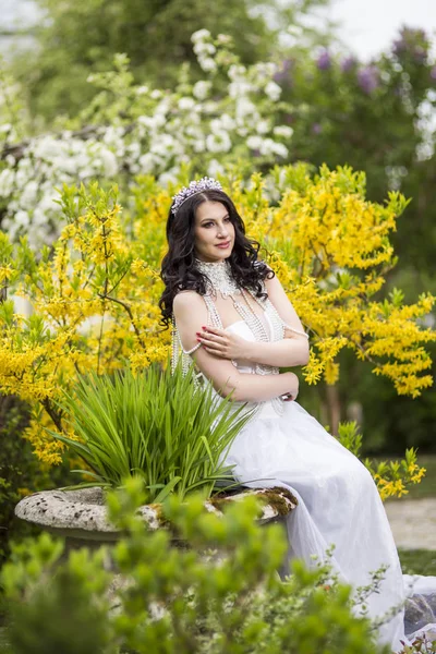 Caucasian Brunette in Flowers Garden Outdoors.Wearing Diadem