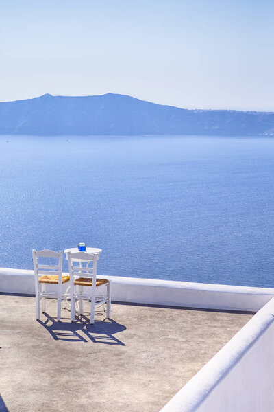 Pair of White Chairs on The Edge of The Roof in Thira City of Santorini
