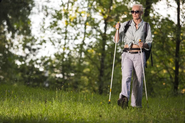 Seniors Sports and Healthy Lifestyle Concepts. Mature Caucasian Woman Having Fitness Nordic Walking