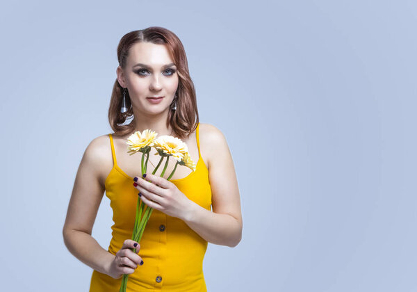 Портрет молодой кавказской безмятежной женщины, позирующей с цветами
 