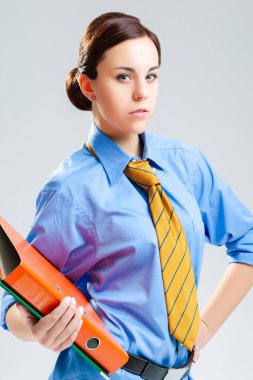 Mavi Ofis Gömlekli Kendine Güvenen Beyaz Kadın ve Kravatlı Renkli Klasörlerin Doğal Portresi. Dikey Resim