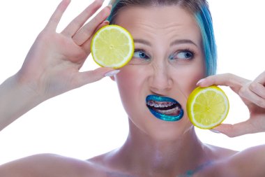 Dişlerinde diş teli olan, beyaz tenli bir kadının güzel portresi. Beyazlara karşı sarı limonlu poz. Diş Sağlığı Ürünlerinizi tanıtıyoruz. Yatay Resim Yönlendirmesi