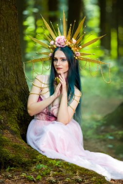 Kostüm oyunu. Yeşil Arkaplanlı Boş Orman 'da Çiçekli Altın Taç Pozisyonuyla Muhteşem Taçlı Orman Perisi. Dikey Resim