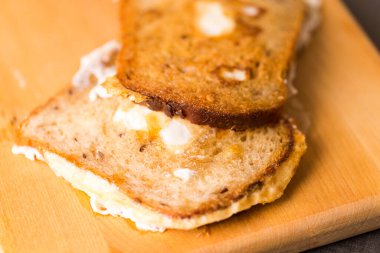 Yumurtalı kızarmış ekmek dilimleri var. Kapalı alan tahtasının üzerine yerleştirilmiş. Yatay görüntü