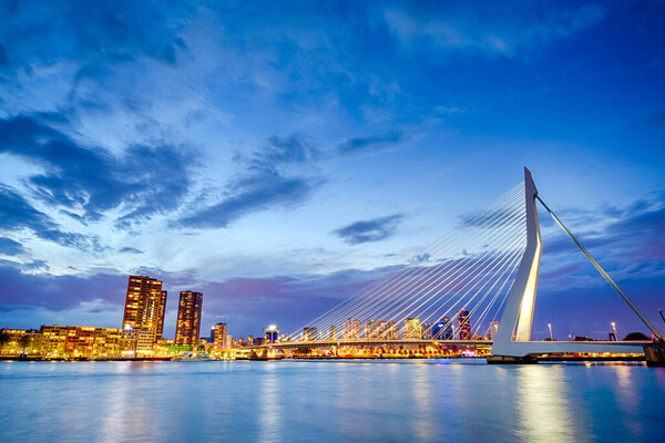 Путешествие по Нидерландам. Ночной вид на знаменитый Эрабрюг (Суанский мост) в Роттердаме перед портом с гаванью. Стреляйте в сумерках. Горизонтальное изображение