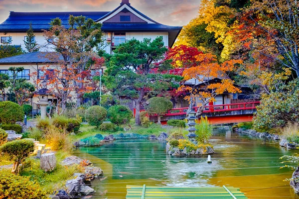 Japan Travel Destinations. Japanese Monastery During Seasonal Red Maples and Pond With Lantern on Sacred Mount Koyasan in Japan. Horizontal Image Composition