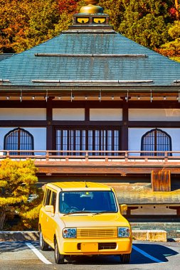 Japonya 'daki Kutsal Koyasan Dağı' ndaki geleneksel Budist Manastırı 'nın önündeki küçük sarı araba. Dikey Görüntü