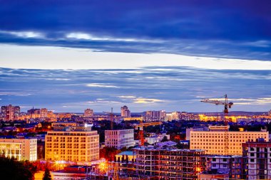 Geceleyin Minsk City Panoraması 'nda Şafak' ta inşaat alanı ve inşaat vinçleri var.