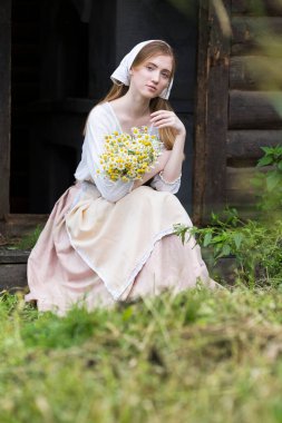 Kırsalda Dinlenen Kırsal Tarzlı Sarışın Kızın Portresi. Köyde papatya sürüsüyle poz vermek. Dikey Resim