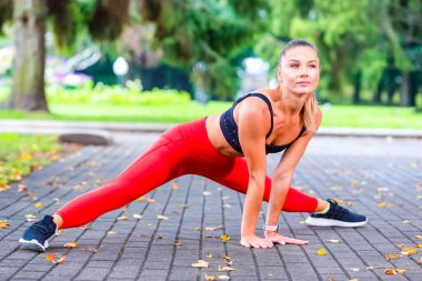 İleri Germe Vücut Egzersizleri Sırasındaki Seksi Kafkas Kadın Koşucusu Gündüzleri Açık Hava 'da. Yatay Resim
