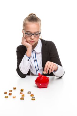 Kara Ceketli Genç Kızın Tasarruf İçin Piggybank 'a Para Koyan Portresi. Dikey Çekim