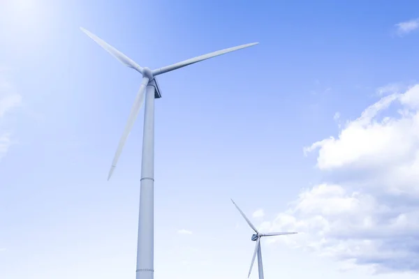 Alternative Energy Concepts. Two Windmills Outdoors Against Blue Sky. Horizontal image