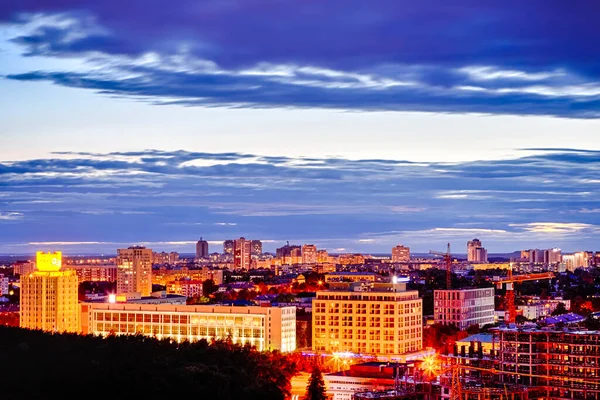 Gece Minsk şehrinin panoramik görüntüsü. Şantiyede inşaat alanı ve vinçler inşa ediliyor. Yatay çekim.