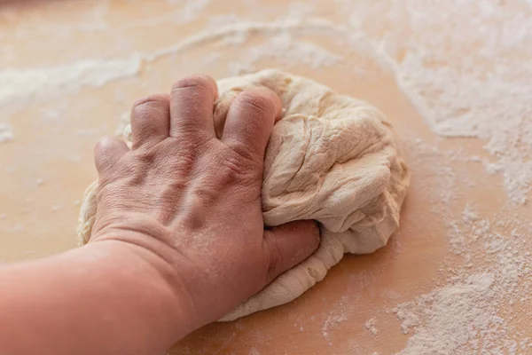 Рука белого человека разминает тесто . — стоковое фото