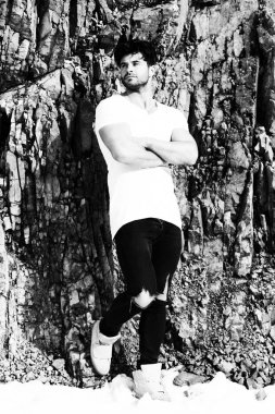 Kamera - kopya alanı tuğla duvara karşı ayakta bakarak kot pantolon giysili yakışıklı genç adam portresi