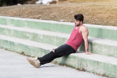 Siyah kot - kaslı atletik vücut Fitness Model açık havada - bir yer, metniniz için poz giyen süre ayakta güçlü kasların esneme sağlıklı genç adam