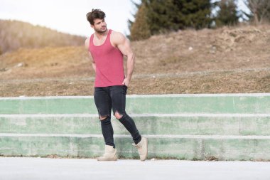 Genç bir portresi, fiziksel olarak iyi eğitimli bedeni siyah kot - kaslı atletik vücut Fitness Model açık havada - bir yer, metniniz için poz giyerken gösterilen adam uygun