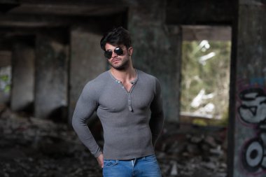 Genç bir portresi fiziksel olarak vücut - kaslı atletik vücut Fitness Model sonra egzersizleri bir Graffiti Duvar önünde poz onun iyi eğitimli gösterilen gri uzun kollu gömlekli adam uygun