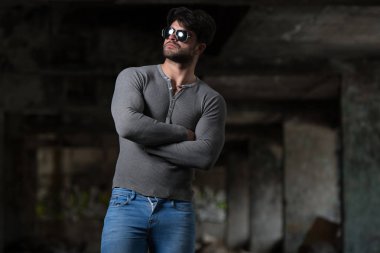 Genç bir portresi fiziksel olarak vücut - kaslı atletik vücut Fitness Model sonra egzersizleri bir Graffiti Duvar önünde poz onun iyi eğitimli gösterilen gri uzun kollu gömlekli adam uygun