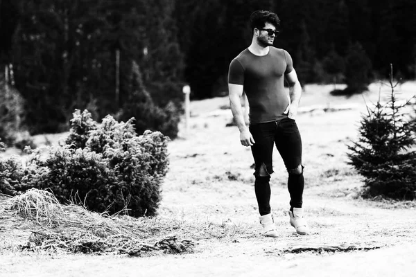 一个年轻的身体健康的人的肖像显示他训练有素的身体 而穿着黑色牛仔裤 肌肉运动健美健身模型户外 一个地方为您的文本 — 图库照片