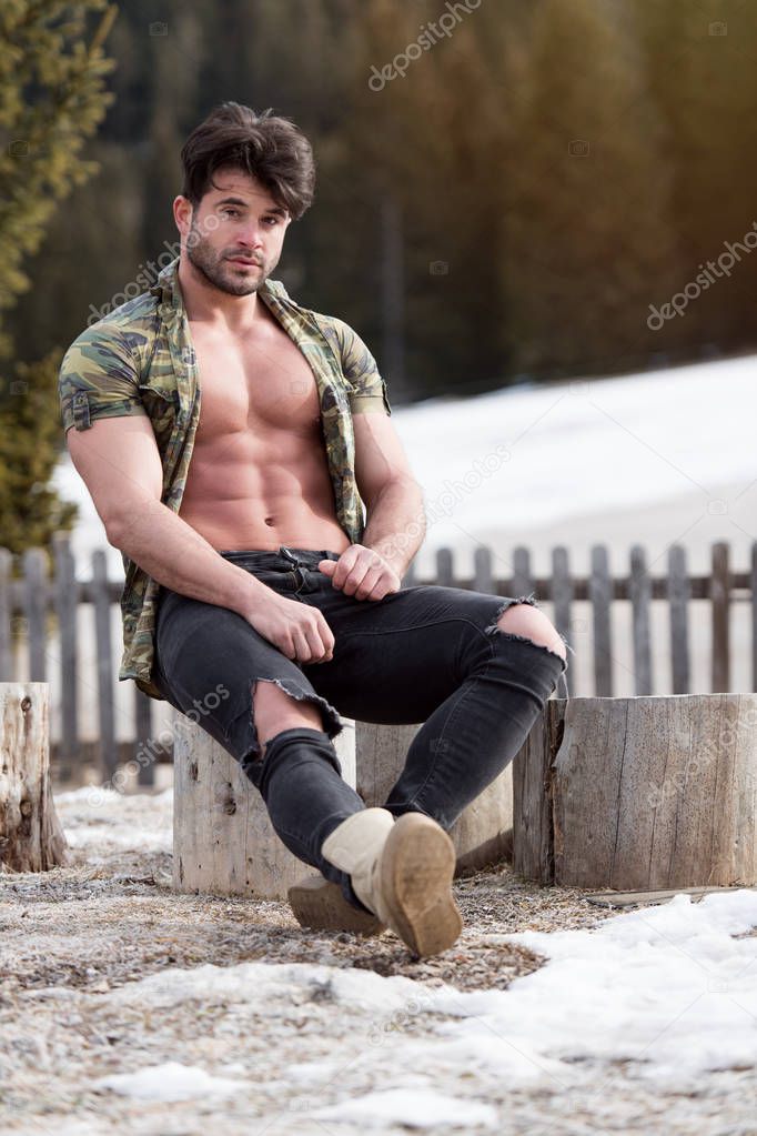 Healthy Young Man Standing Strong Flexing Muscles While Wearing Black Jeans - Muscular Athletic Bodybuilder Fitness Model Posing Outdoors - a Place for Your Text