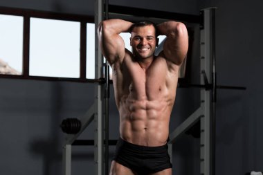 İyi eğitilmiş vücudunu gösteren genç bir adamın portresi - kaslı atletik vücut geliştirici spor sonrası vücut geliştirme modelliği pozu