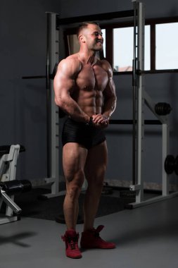 İyi eğitilmiş vücudunu gösteren genç bir adamın portresi - kaslı atletik vücut geliştirici spor sonrası vücut geliştirme modelliği pozu