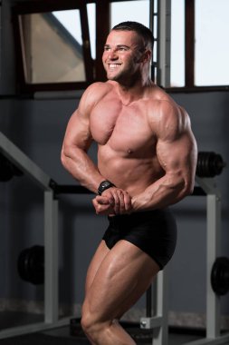 İyi eğitilmiş vücudunu gösteren genç bir adamın portresi - kaslı atletik vücut geliştirici spor sonrası vücut geliştirme modelliği pozu