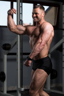 Spor Salonunda Güçlü Duran Genç Adam - Kas Atletik Vücut Geliştirici Spor Sonrası Spor Pozisyonu
