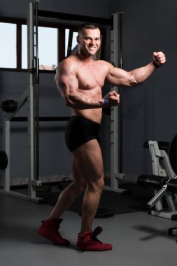İyi eğitilmiş vücudunu gösteren genç bir adamın portresi - kaslı atletik vücut geliştirici spor sonrası vücut geliştirme modelliği pozu