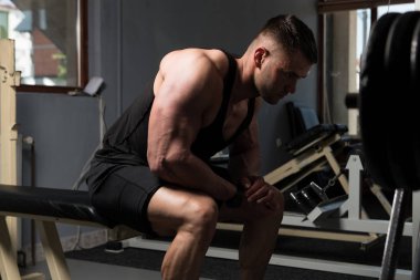 Yakışıklı ve çekici bir genç adam. Vücut kasları spor salonunda dinleniyor.