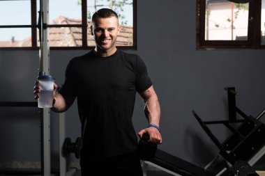 Kaslı adam egzersiz sonrası dinlenme ve Shaker içme