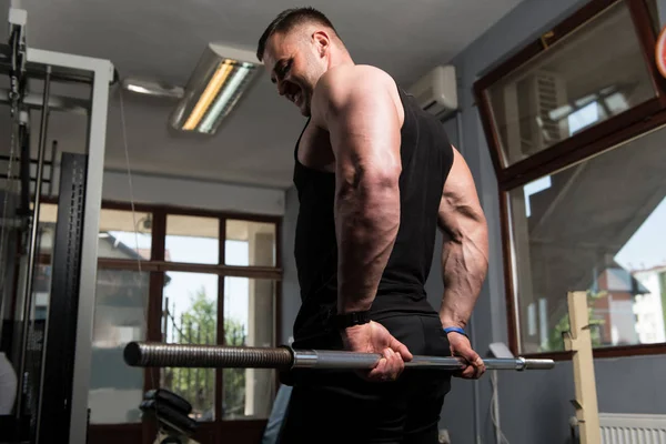 肌肉男做重的运动前臂与杠铃在健身房 — 图库照片