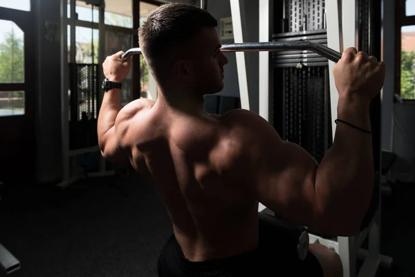 Knappe Atleet Doet Zware Gewicht Oefening Voor Terug Machine — Stockfoto