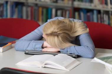 Bir alan lise - Üniversite Kütüphanesi - sığ derinliği uyuyan güzel kız öğrenci ile kütüphanede kitap
