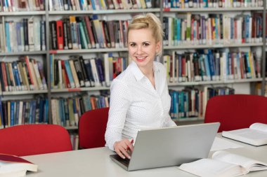 Sınav hazırlama ve dersler okul kütüphanesinde öğrenme - Laptop ve Gözat Internet üzerinde araştırma kütüphanede yapma öğrenci