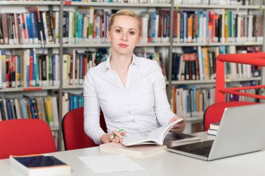 Bazı okul işi kütüphanede bir dizüstü bilgisayar ile bir çekici öğrenci portresi