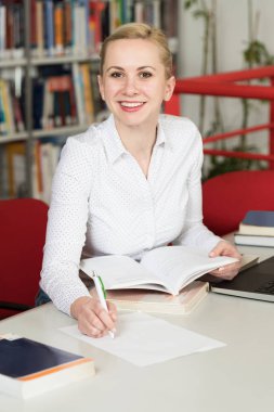 Kütüphanede - kız öğrenci bir alan lise - Üniversite Kütüphanesi - sığ derinliği çalışma kitapları ile güzel