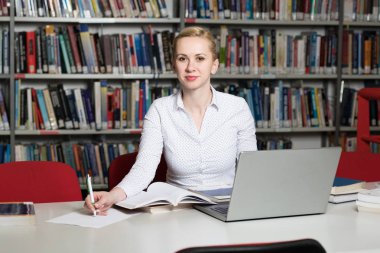 Kütüphanede - kız öğrenci bir alan lise - Üniversite Kütüphanesi - sığ derinliği çalışma kitapları ile güzel