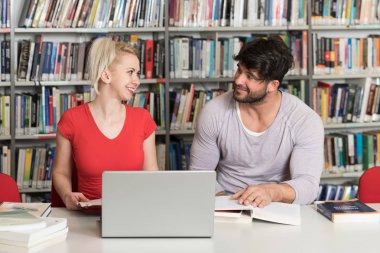 Bazı okul işi kütüphanede bir dizüstü bilgisayar ile bir çekici öğrenci portresi