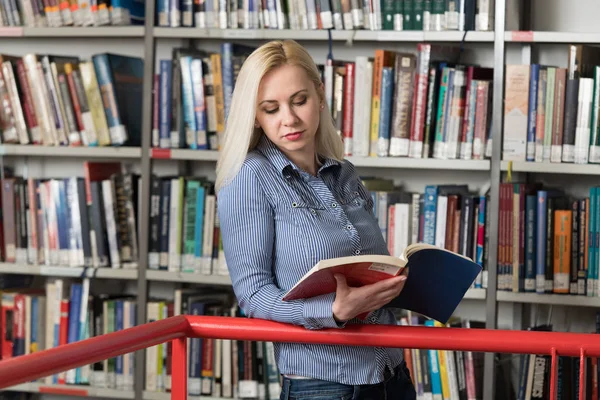 Vacker Kvinna Med Blont Hår Står Biblioteket Suddig Böcker Baksidan — Stockfoto