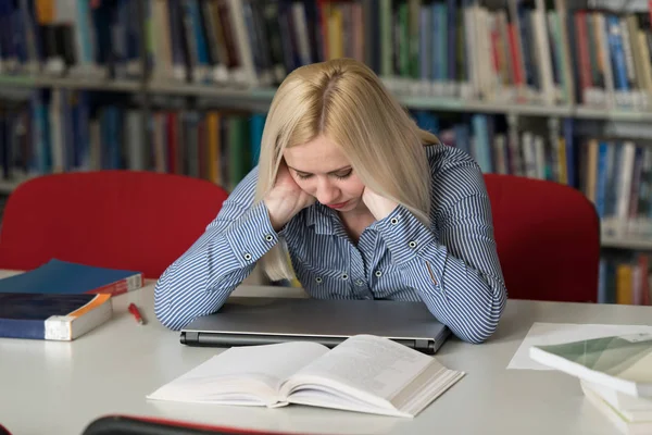 Jovem Estudante Estressada Lendo Livro Enquanto Está Sentado Biblioteca — Fotografia de Stock